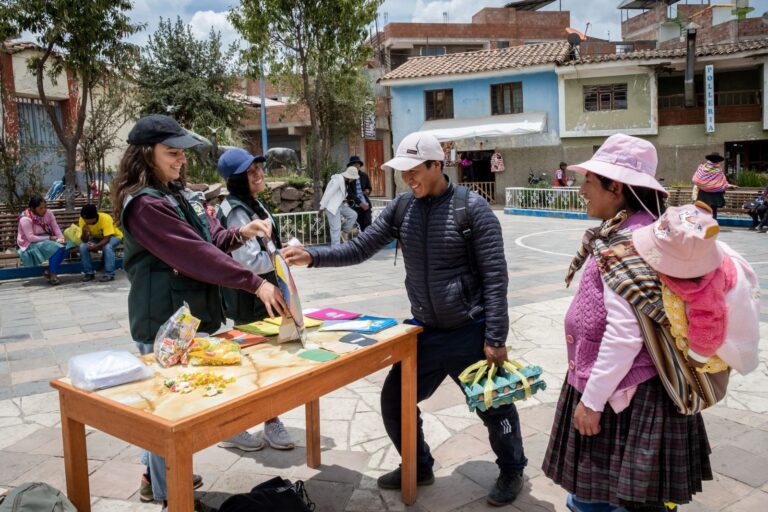 Menschen interagieren an einem Infostand auf einem belebten Platz