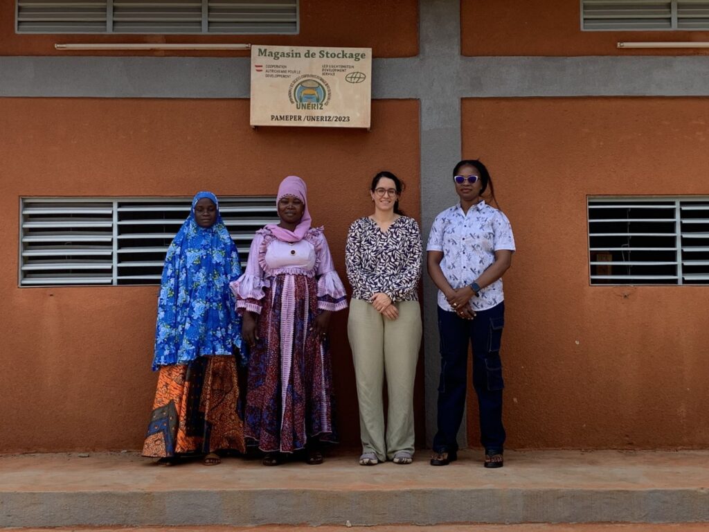 Four women in front of a warehouse with an LED sign in Niger