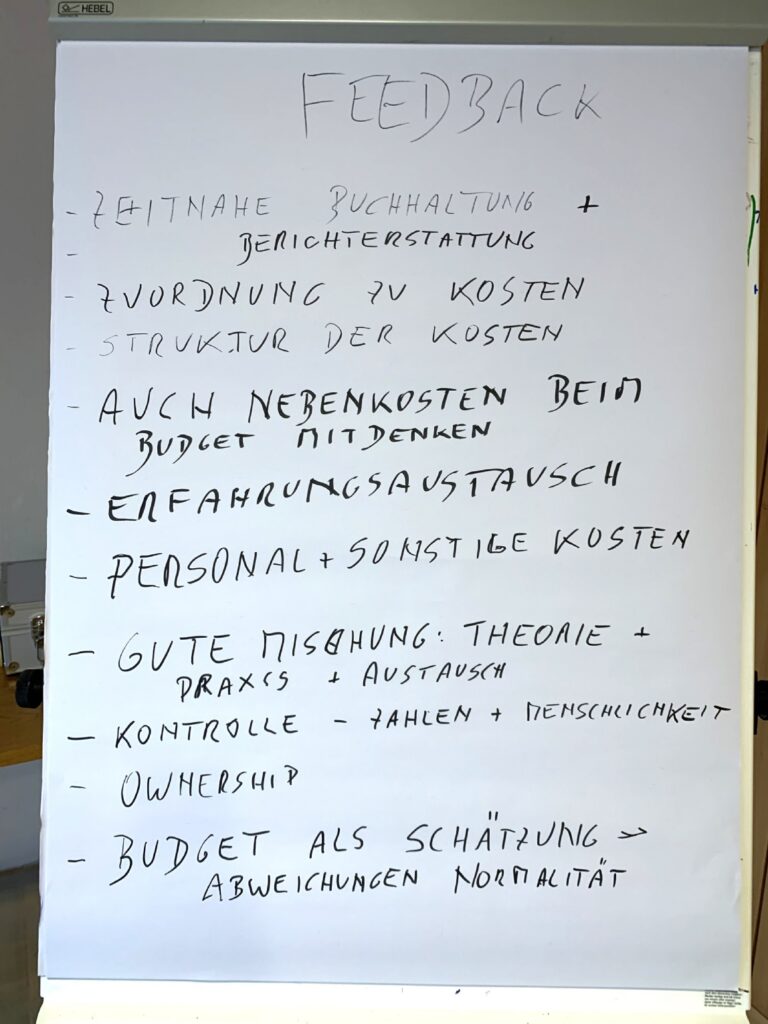 Flip chart with handwritten German feedback notes on budgeting, costs, control, and ownership
