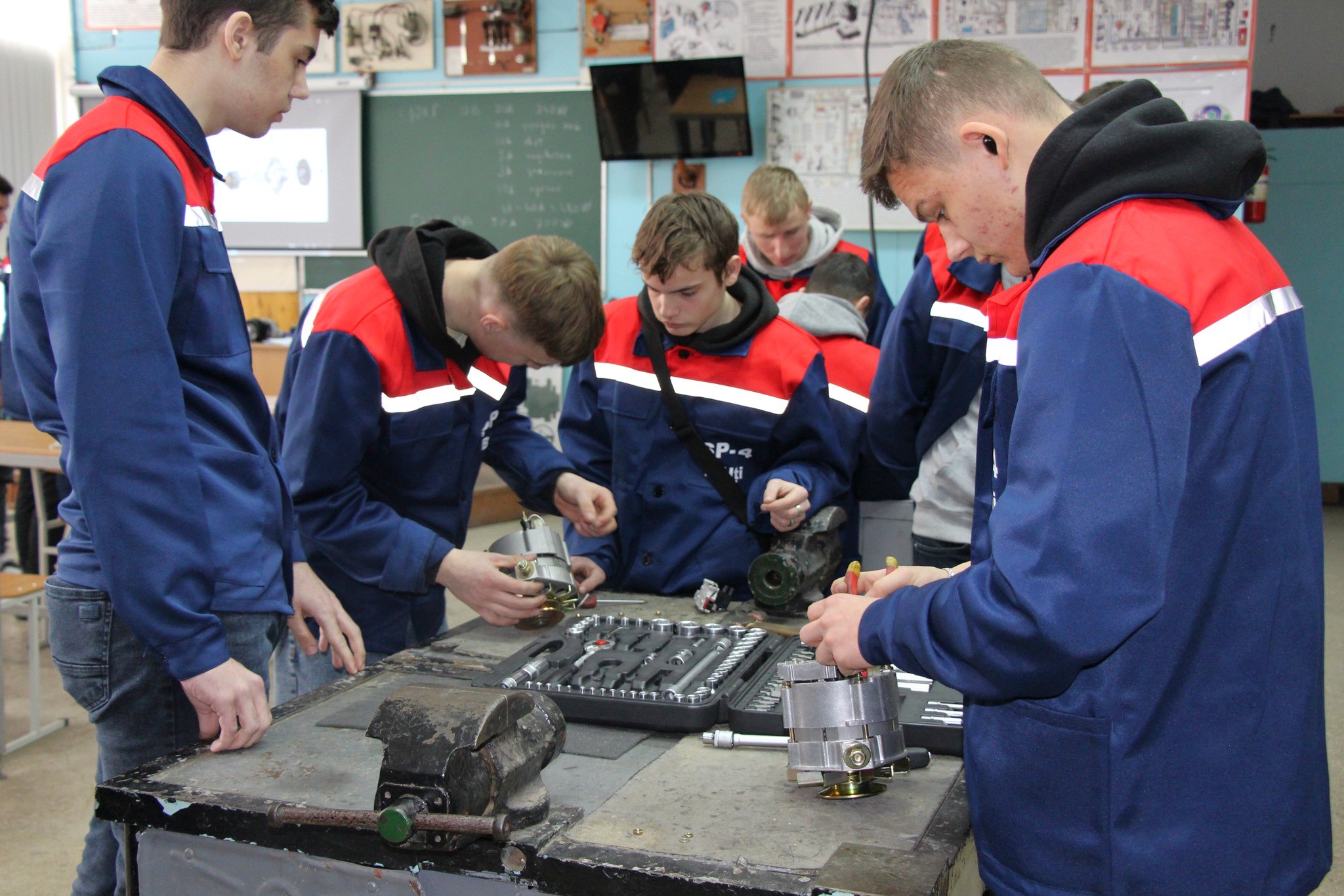 Young men in blue work suits during technical training