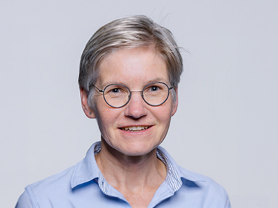 Older woman with glasses and short hair in a blue shirt