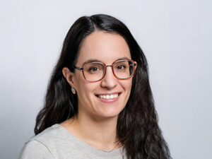 Lächelnde Frau mit Brille vor hellem Hintergrund, Porträt