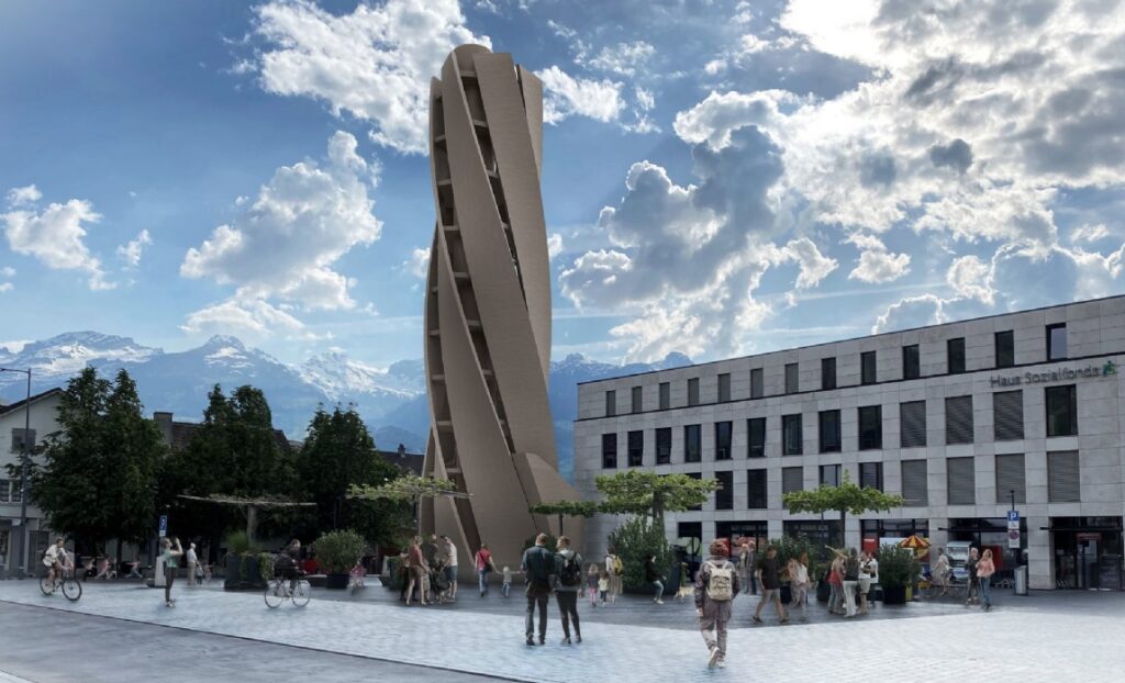 Modern public square with a tall sculptural tower, pedestrians, and mountain backdrop