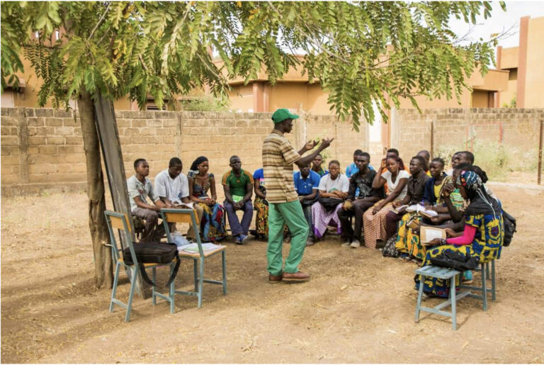 Gruppe von Menschen in einem Outdoor-Workshop unter einem Baum